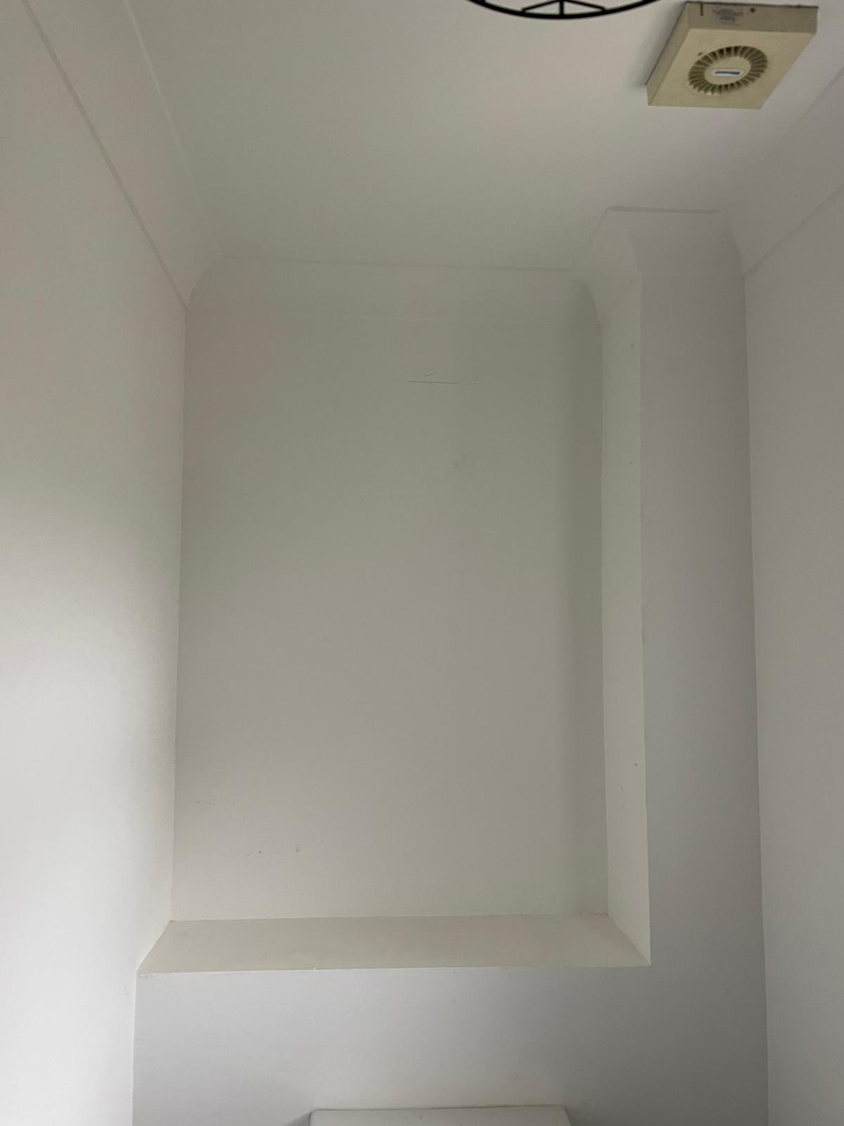 Empty bathroom alcove above a toilet before storage was fitted