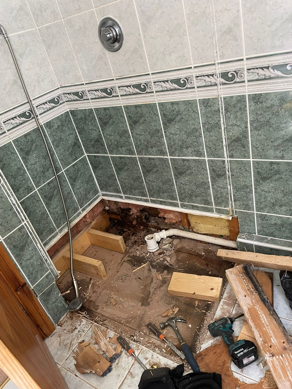 Bathroom floor and pipework exposed during a shower replacement